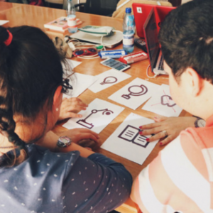 Picture of two people seeing symbols in paper squares on a table.