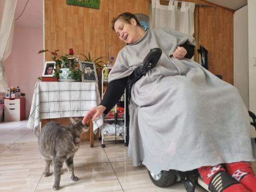 Soledad acariciando a su "niño": mi ayudante gatuno en el cuidado de mi mamá.